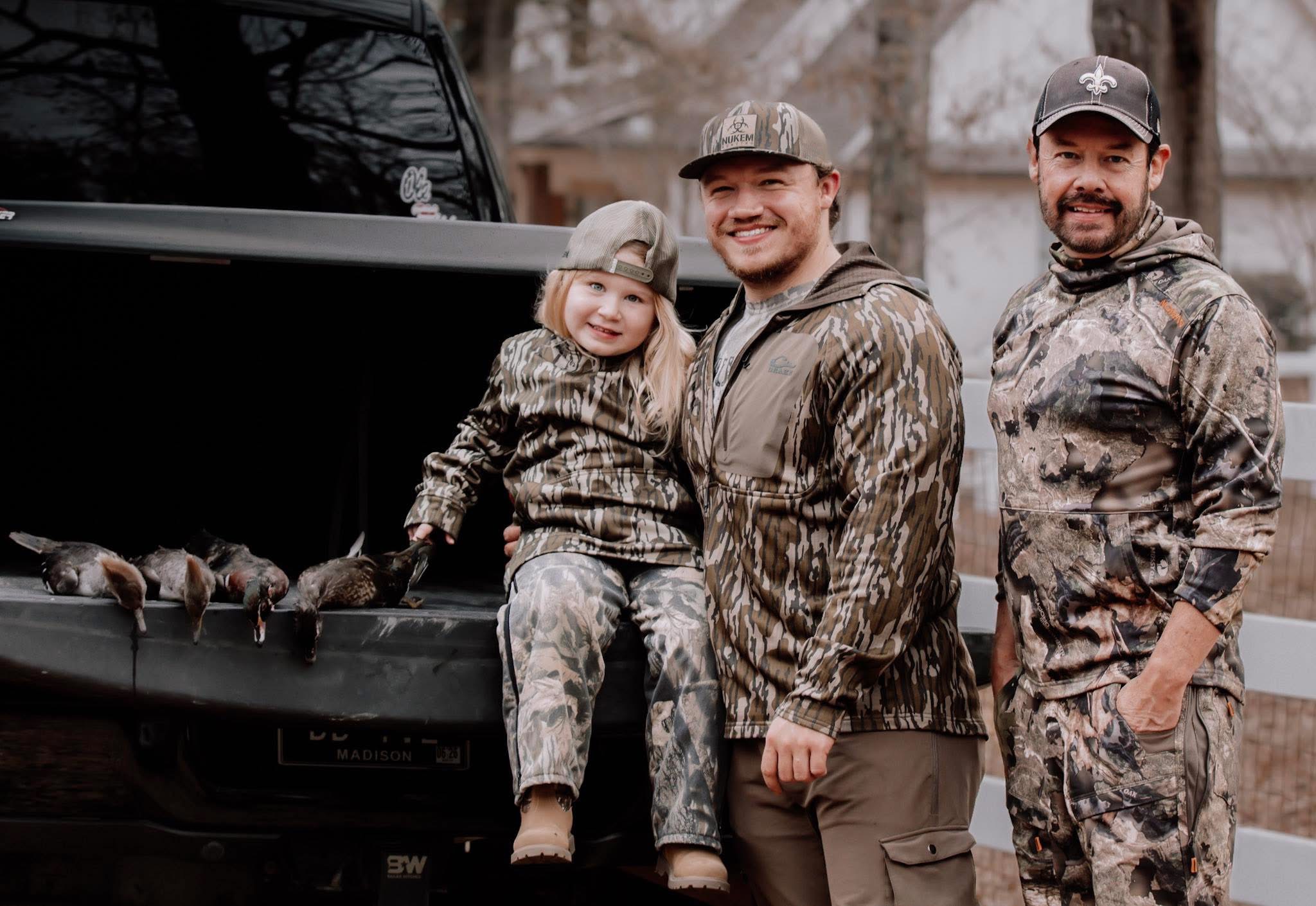 A father and child with a harvested deer