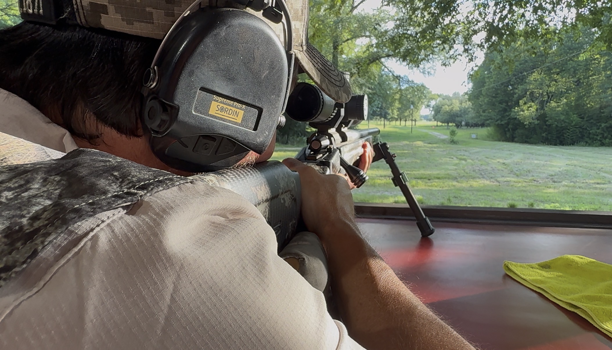 A hunter looking through a scope from a blind