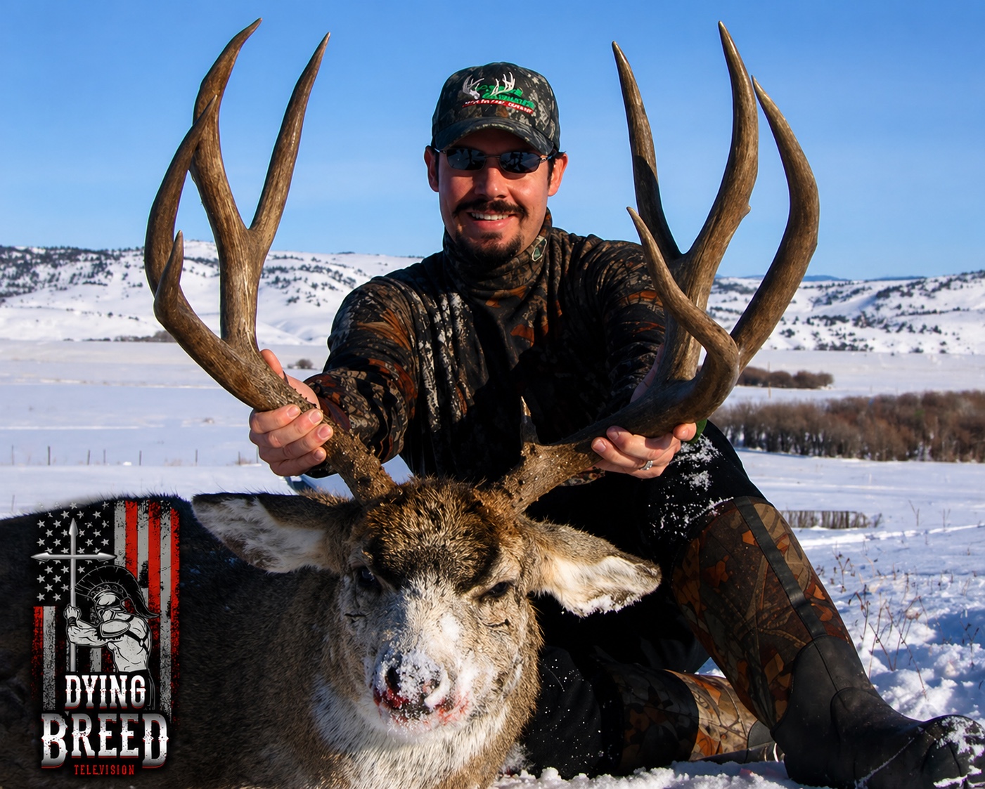 Shawn Chatham holding a mature whitetail in the snow
