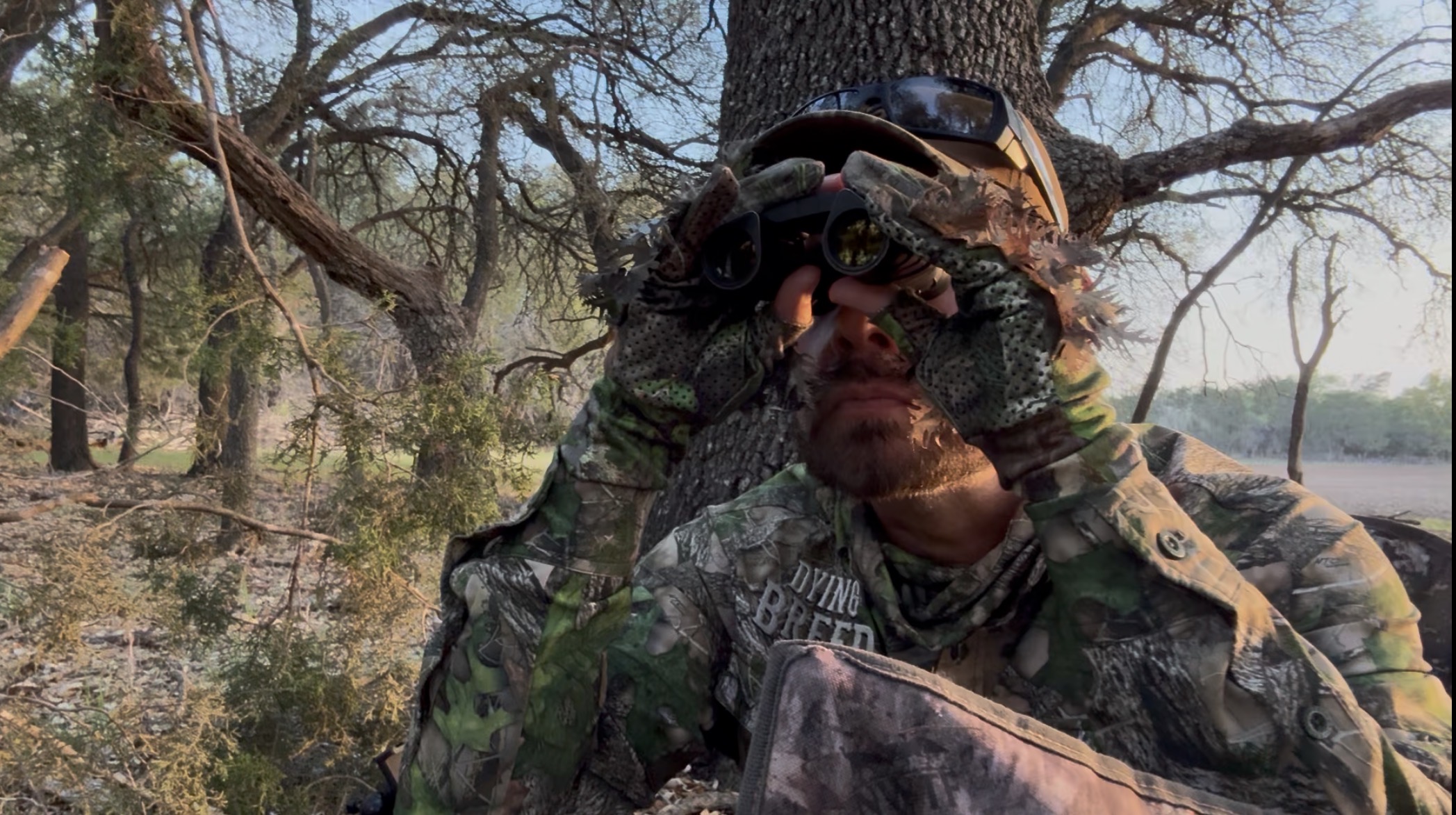A hunter tucked into cover in the field