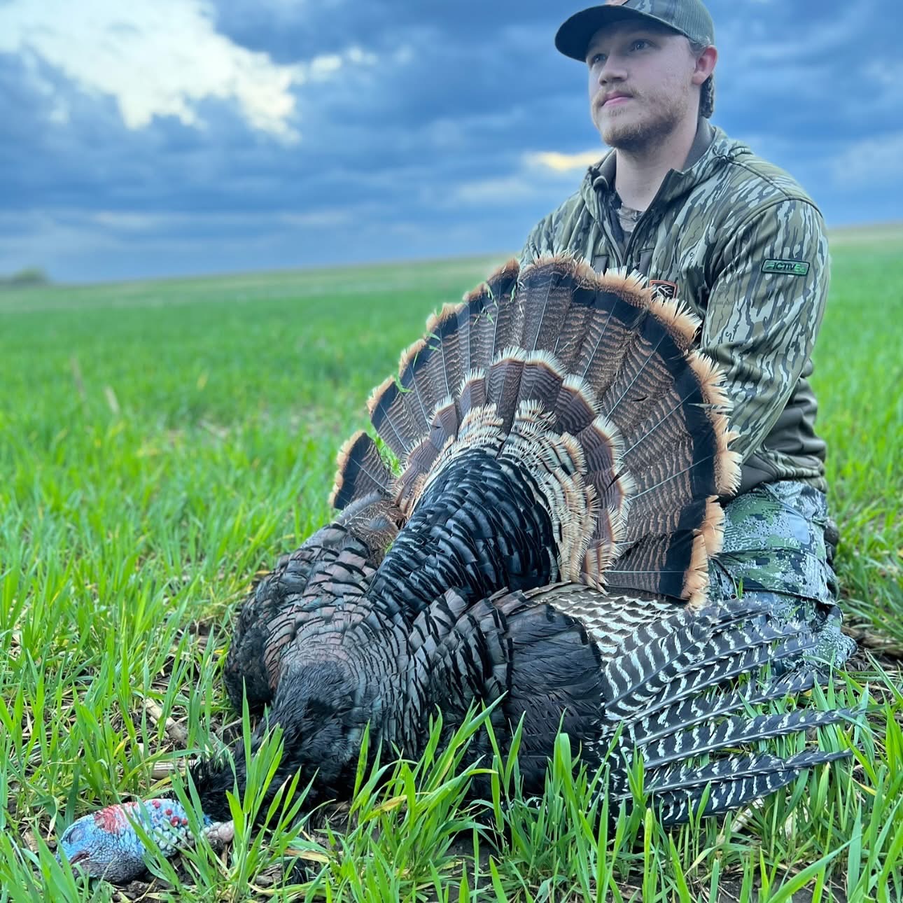 A hunter with a turkey in a field