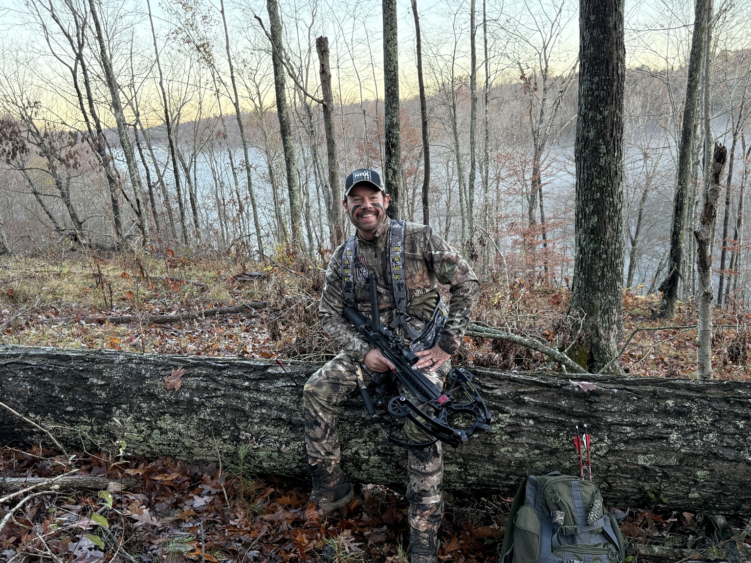 A hunter seated outdoors with a mature whitetail